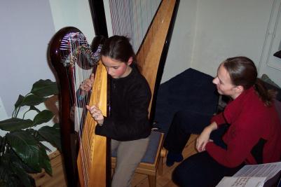 [Foto: Nienke van Loon krijgt harples op Keltische
  harp]